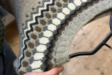 Ein gestrickter Pullover mit einem mehrfarbigen Muster