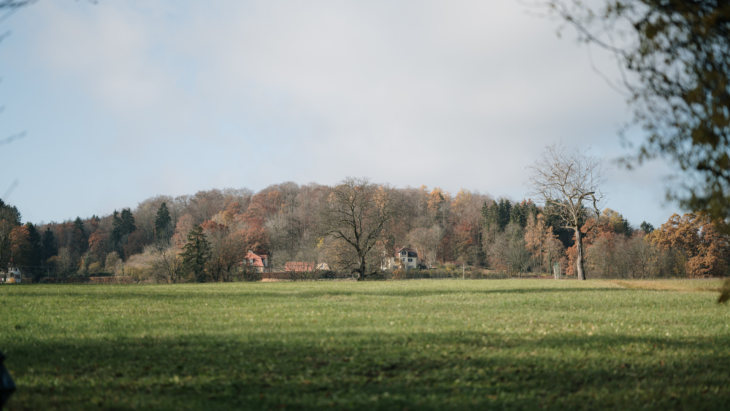 Das Haus, in dem Johnnes Sift lebt, von außen aus der Ferne. Man sieht viel Natur drumherum, Bäume und weite Wiesen.