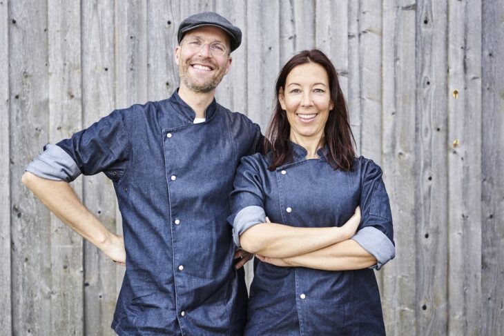 Benedikt und Corinna Fuhrmann in ihren Kochjacken aus dunkelblauem, denimartigen Stoff